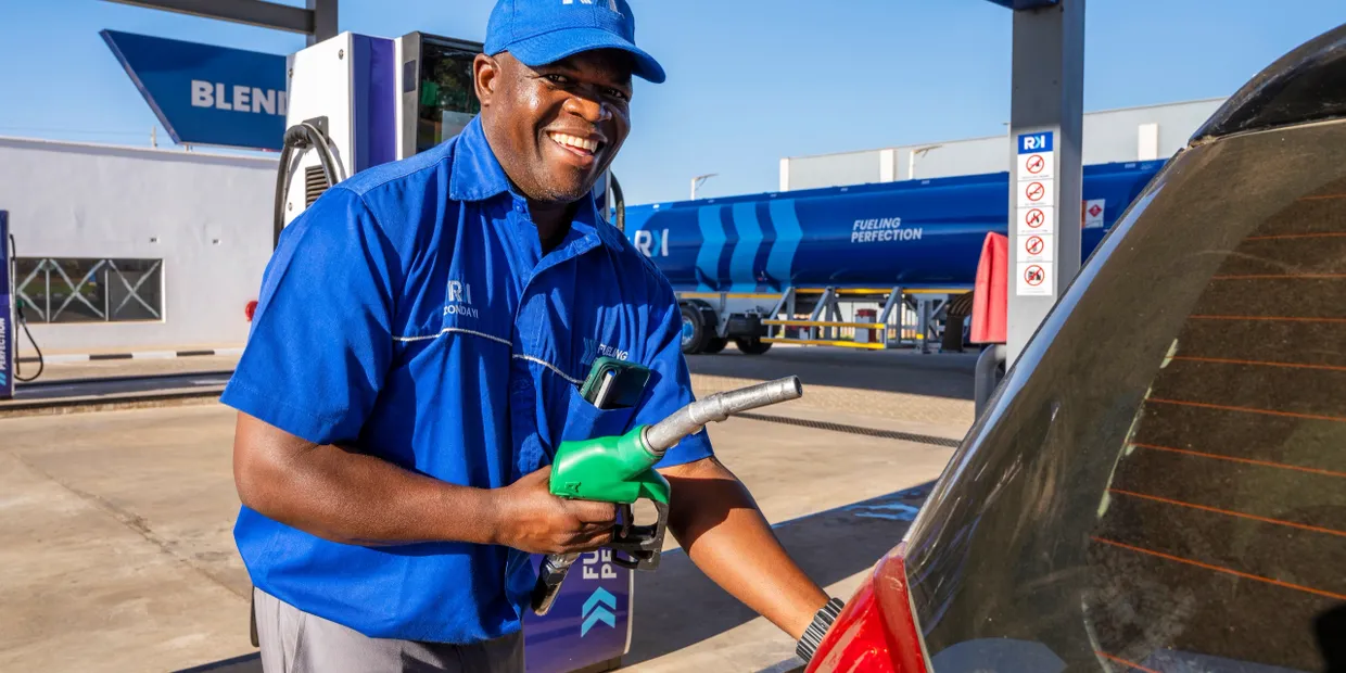 Fuel attendant serving customer with a smile